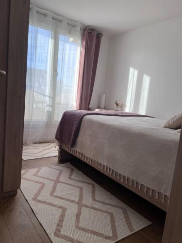 une chambre avec un lit et une grande fenêtre dans l'établissement Cosy Flat - Villiers City Center - RER A & E - between Paris & Disney, à Villiers-sur-Marne