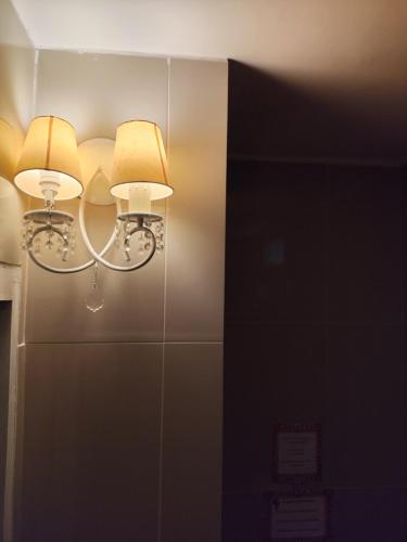 a pair of lights on a wall with a mirror at Kabatukila Pousada in Natal