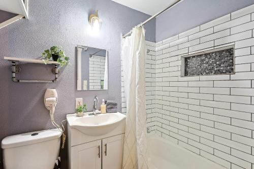un bagno con lavandino, WC e doccia di Comfy and Modern Holiday Lofts in FW a Fort Worth