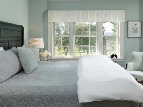 a bedroom with a large white bed and a window at Devonfield Inn in Lee