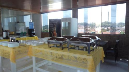 a kitchen with a yellow table with dishes on it at Pousada Vela Mar in Maragogi
