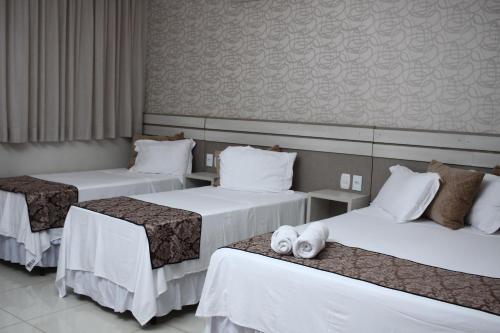 シノプにあるSonus Hotelの白いシーツが敷かれたベッドが3つあるホテルの部屋