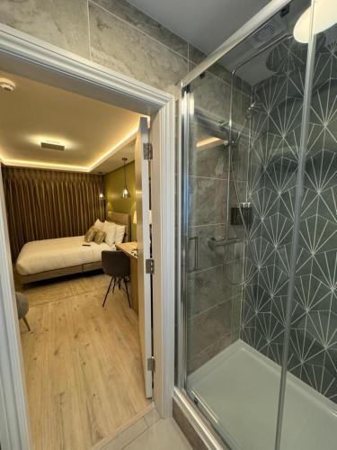 a bathroom with a shower and a bedroom with a bed at Birdies Townhouse Mitchelstown in Mitchelstown