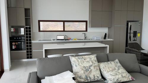 ハマにあるLujoso departamento Jama Manabí con vista al Marのソファとキッチンのあるリビングルーム