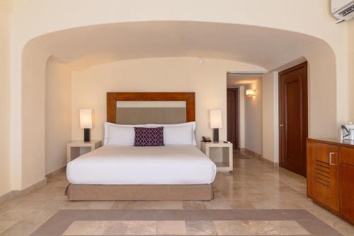 a bedroom with a white bed and two lamps at Camino Real Acapulco Diamante in Acapulco