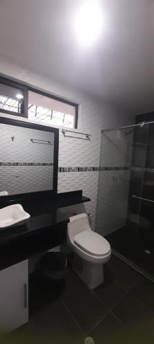 a bathroom with a toilet and a sink and a shower at Quinta Isabel in Ibagué