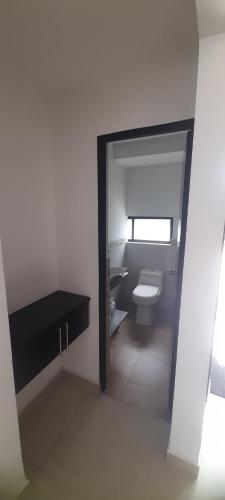 a white bathroom with a toilet and a sink at Quinta Isabel in Ibagué