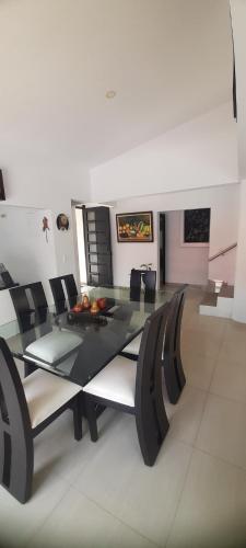 a dining room with a glass table and chairs at Quinta Isabel in Ibagué