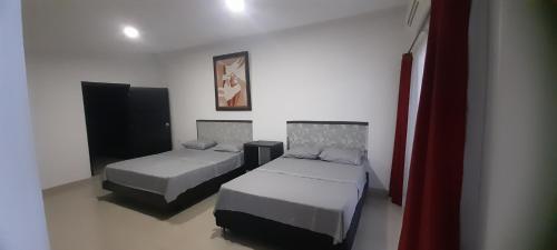 a room with two beds and a tv in it at Quinta Isabel in Ibagué