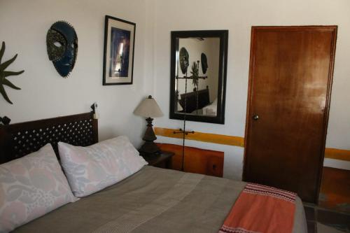 a bedroom with a bed and a wooden door at Casa Artista in Manzanillo