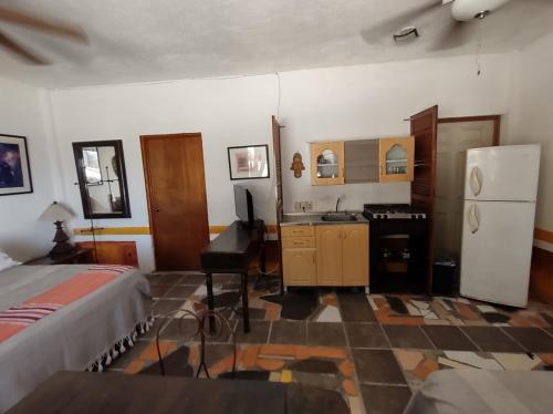 a kitchen with a refrigerator and a sink in a room at Casa Artista in Manzanillo