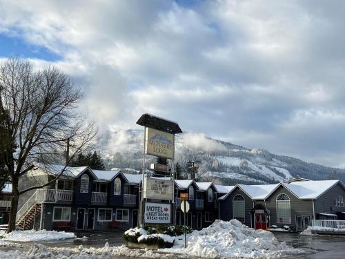 a sign in front of a snow covered building at Monashee Lodge in Revelstoke