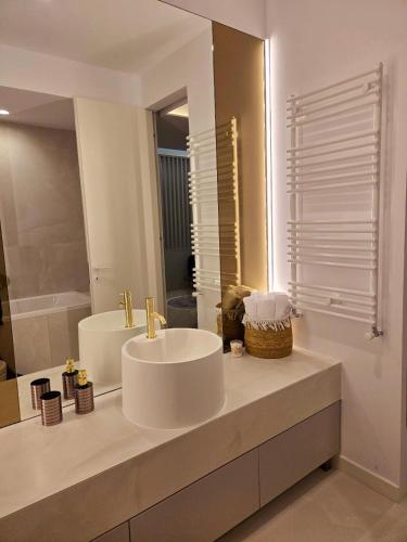a white bathroom with a sink and a mirror at Happy Studio Luxury Cortina North in Voluntari