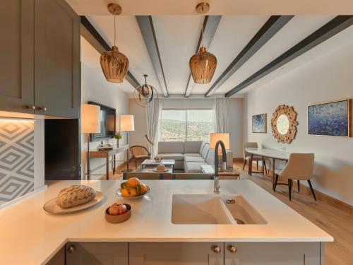 a kitchen with a sink and a living room at Viceroy Residences at Ombria Algarve in Loulé
