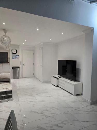 a living room with a flat screen tv on a white wall at A stylish 3 bedroom house or Apartment in Greenhithe - Available for booking as individual Room or as a Whole apartment - 11mins walk to Greenhithe Train Station, 7 mins drive to Bluewater shopping mall in Greenhithe