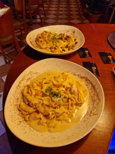 two plates of pasta on a wooden table at Hotel Restaurant Oliva in Nordwalde