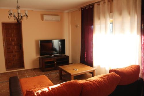 a living room with a couch and a television at Casablanca in Candeleda
