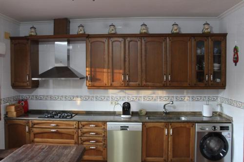 a kitchen with wooden cabinets and a sink at Casablanca in Candeleda