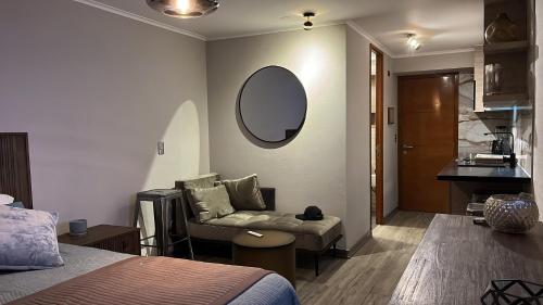 a bedroom with a bed and a chair and a mirror at Roca Town House in Viña del Mar