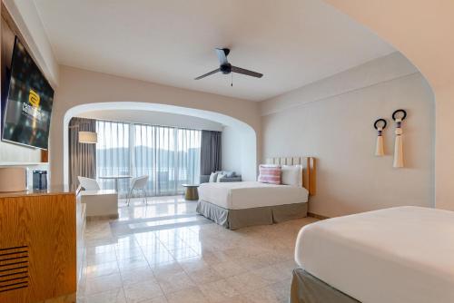 a hotel room with two beds and a ceiling fan at Camino Real Acapulco Diamante in Acapulco
