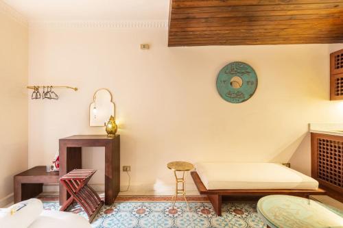 a room with a bed and a table and a stool at The Majestic Marrakesh Studio Cairo's Downtown 19A in Cairo