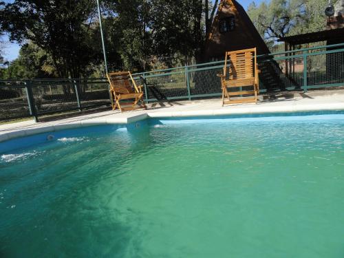 two chairs sitting in a pool of water at Cabañas Valle Dorado in Villa Rumipal