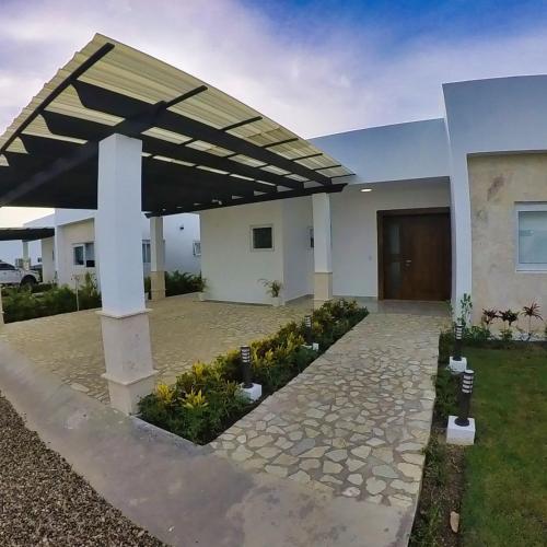 a building with awning over a courtyard with flowers at Villa Ruby Bella in Sosúa