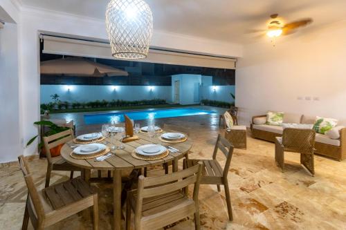 a dining room with a table and chairs and a pool at Villa Ruby Bella in Sosúa