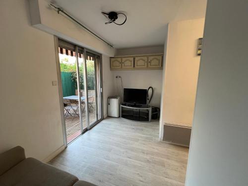 un salon avec un canapé et une télévision dans l'établissement Charme et Soleil Côte d'Azur, à Antibes