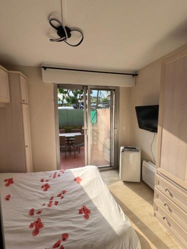 une chambre avec un lit avec des fleurs rouges dessus dans l'établissement Charme et Soleil Côte d'Azur, à Antibes