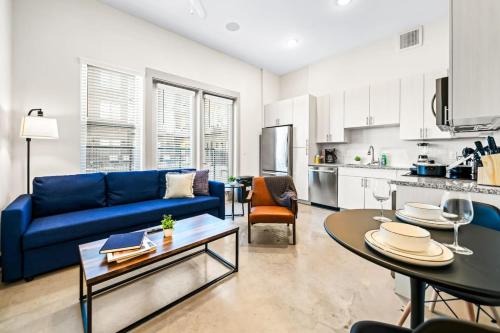 a living room with a blue couch and a table at Serene Retreat Pool 2 Min to TCU in Fort Worth