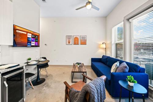 a living room with a blue couch and a table at Serene Retreat Pool 2 Min to TCU in Fort Worth