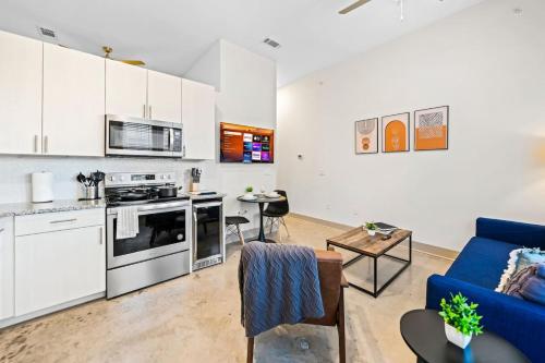 a living room with a blue couch and a kitchen at Serene Retreat Pool 2 Min to TCU in Fort Worth