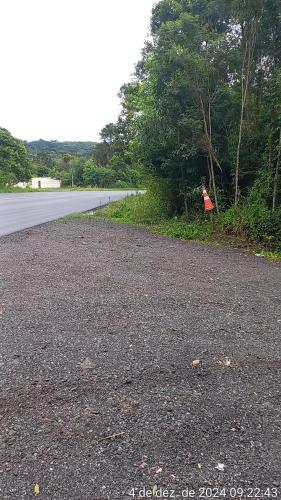 a person sitting on the side of a road at Cabana de pesca e lazer Represa Usina Mafra sc in Mafra