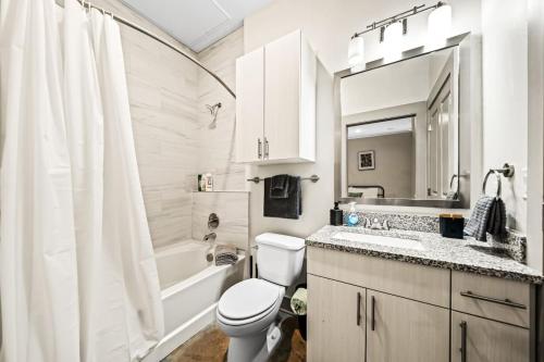 a white bathroom with a toilet and a sink at Serene Retreat Pool 2 Min to TCU in Fort Worth