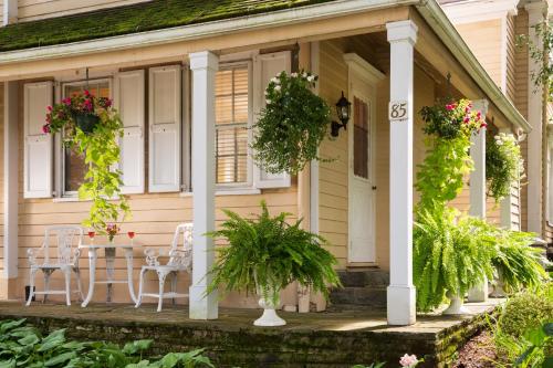 a house with two chairs and a table on the porch at Devonfield Inn in Lee