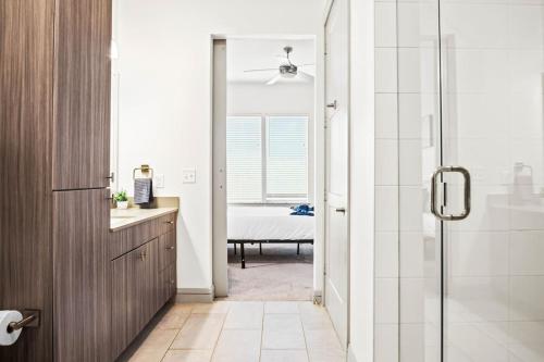 a bathroom with a shower and a sink and a mirror at Luxurious New Unit 1Bd1Ba Pool, Golf Sim in Austin