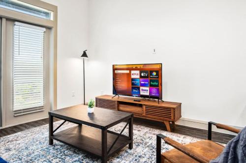 a living room with a tv and a coffee table at Luxurious New Unit 1Bd1Ba Pool, Golf Sim in Austin