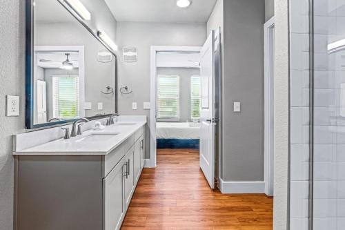 a white bathroom with two sinks and a shower at Fascinating 2BD 2BA w Beautiful Pool in Fort Worth in Fort Worth