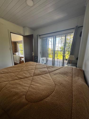 a bedroom with a large bed with a large window at Casa FLORIDA in Villa Serrana