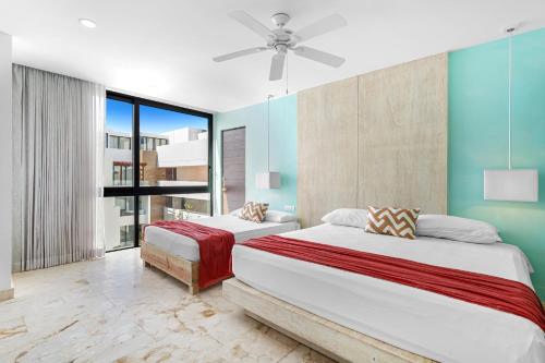 a bedroom with two beds and a ceiling fan at FEISIVA LUXURY Apartament in Playa del Carmen