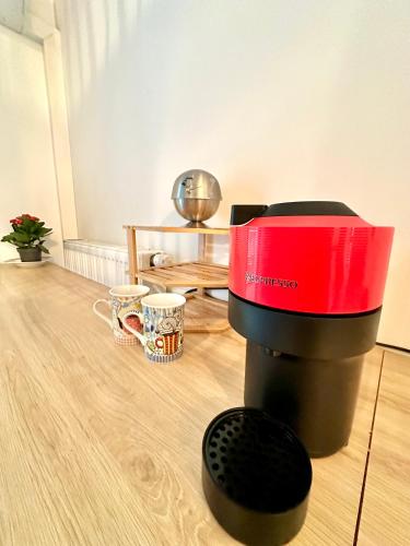 - une cafetière rouge et noire assise sur du parquet dans l'établissement Studio 600 m de la Promenade des Anglais, à Nice