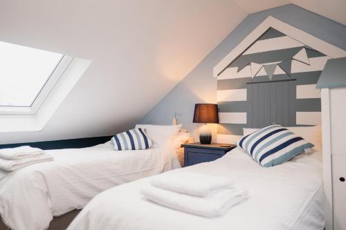 two beds in a attic room with a window at Family & Pet-Friendly Seaside Bungalow with Accessible Features in Minster