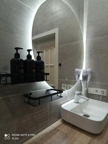 une salle de bain avec un lavabo et un miroir dans l'établissement Двухуровневые апартаменты в ЖК Керемет на Каспийском море, à Aktau