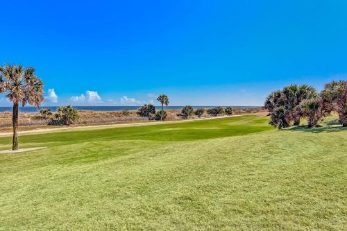 a golf course with palm trees and a green at 1321 Shipwatch in Amelia Island