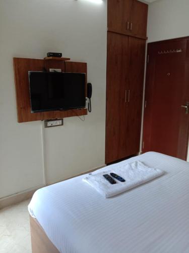 a bedroom with a bed and a flat screen tv at SK BUSINESS hOTEL in Bengaluru