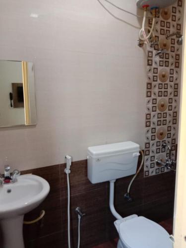 a bathroom with a white toilet and a sink at SK BUSINESS hOTEL in Bengaluru