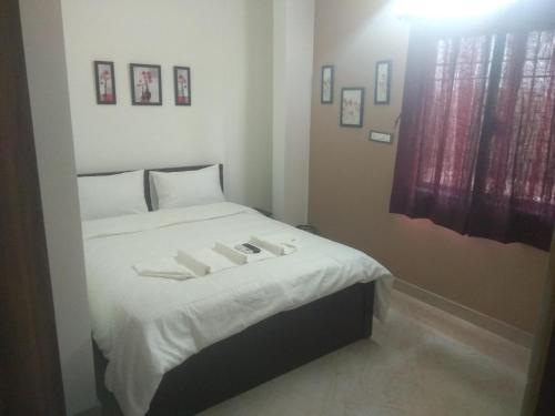 a bedroom with a bed with two white towels on it at SK BUSINESS hOTEL in Bengaluru