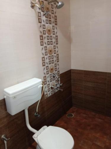 a bathroom with a toilet and a shower curtain at SK BUSINESS hOTEL in Bengaluru