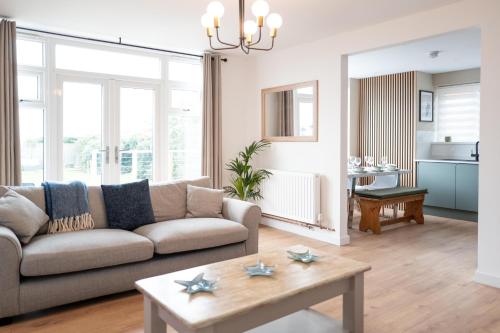 a living room with a couch and a table at Family & Pet-Friendly Seaside Bungalow with Accessible Features in Minster